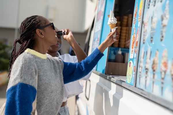lady purchasing cone from ice cream van